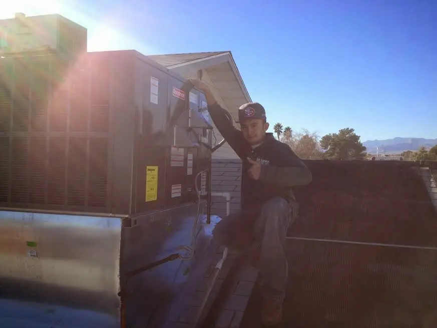 HVAC technician performing Boiler Repair on a rooftop unit in San Bruno